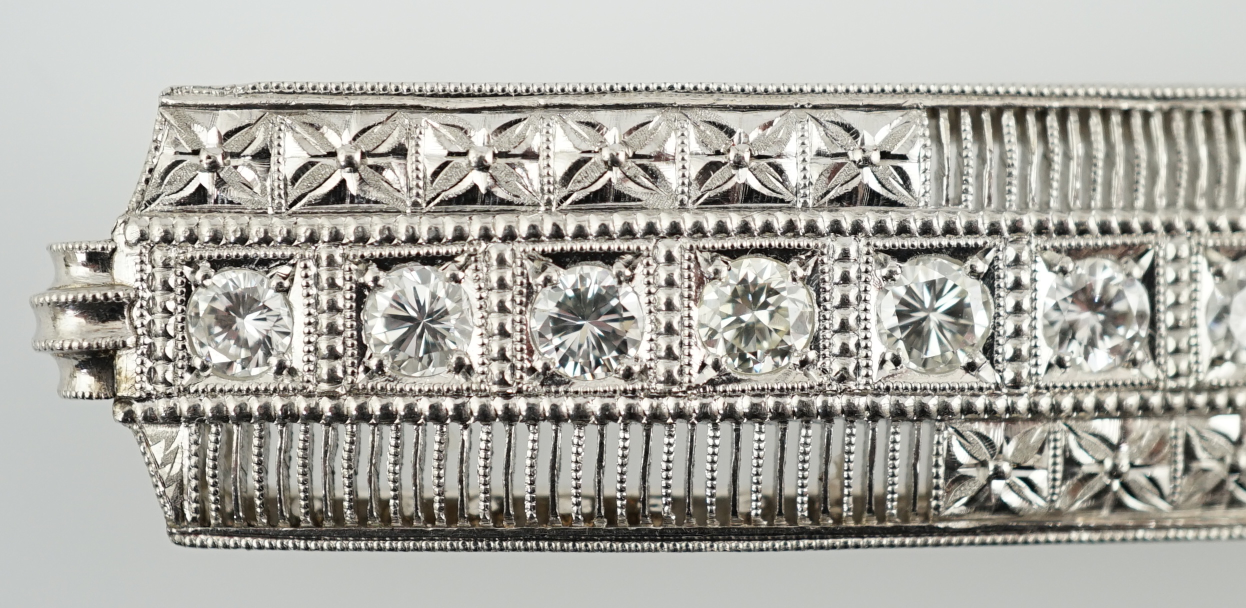 A platinum and eight stone diamond set concave clasp/attachment